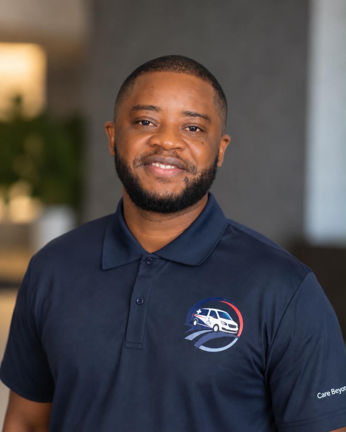 Portrait of David Saah Nyumah, Co-Founder of Monrovia Express Transport LLC, wearing a company-branded navy polo shirt